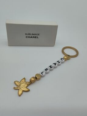 CHANEL Sublimage Lily Keychain Gold Tone Letter Charm With Box Rare NIB